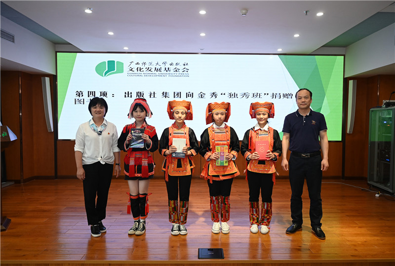 廣西師范大學出版社集團副總裁、工會主席莫曲波（右一）代表出版社向金秀“獨秀班”同學贈送圖書（李顯楊攝）.jpg