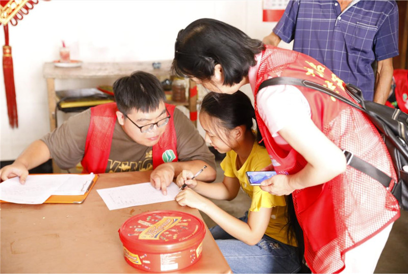 同學(xué)們在志愿者的指導(dǎo)下填寫《入戶調(diào)查表》.jpg
