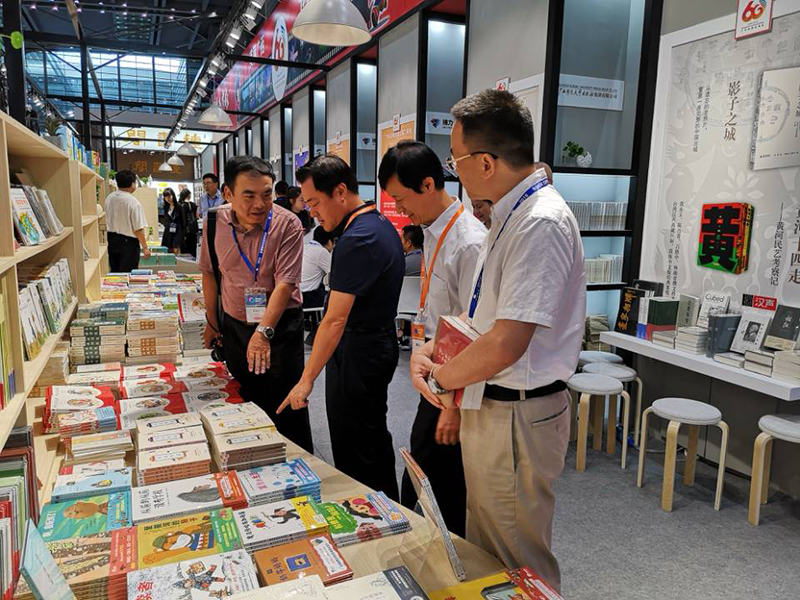 自治區(qū)政協(xié)科教文衛(wèi)體委員會主任委員彭綱（左二），自治區(qū)新聞出版廣電局黨組成員、副局長朱為范（右二）到集團(tuán)公司展位視察.jpg